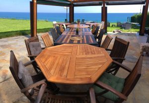 Zona de comedor exterior con mesa de madera y vistas despejadas al mar en casa de lujo en Asturias